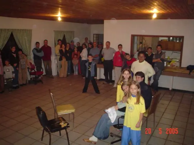 Irmãos de várias idades reunidos no salão social da igreja, à noite