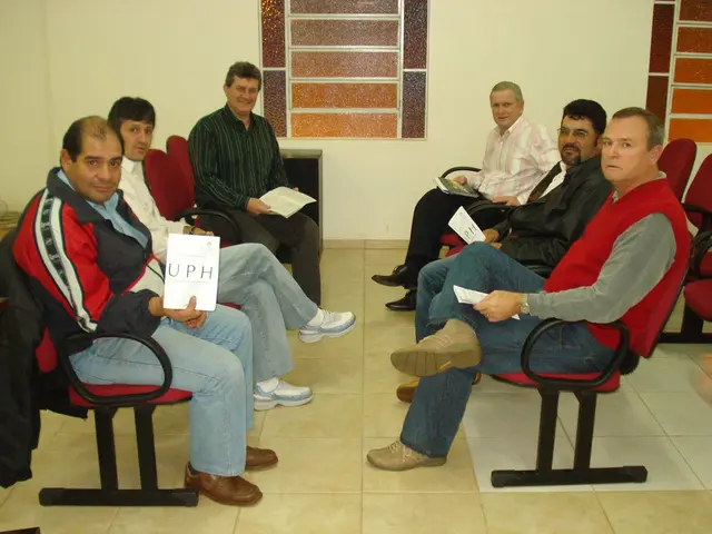 Homens sentados no templo, um deles segurando um livreto