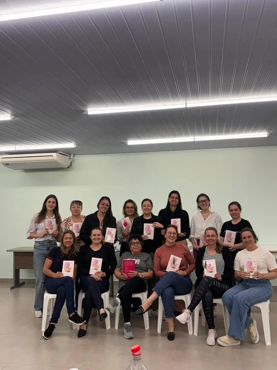 Mulheres do Café Literário reunidas em foto de grupo, cada uma com o seu exemplar do livro