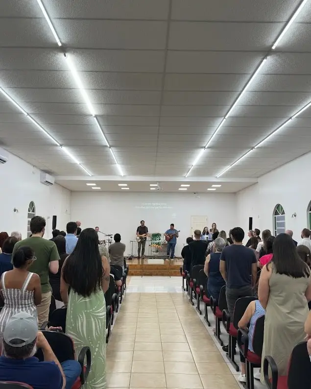 Igreja de pé durante o louvor no culto de adoração