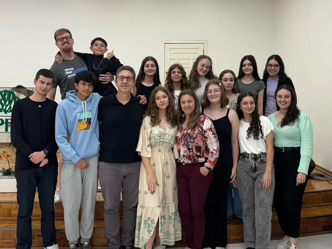 Adolescentes da UPA e líderes reunidos em grupo no salão da IPPB, em frente ao púlpito