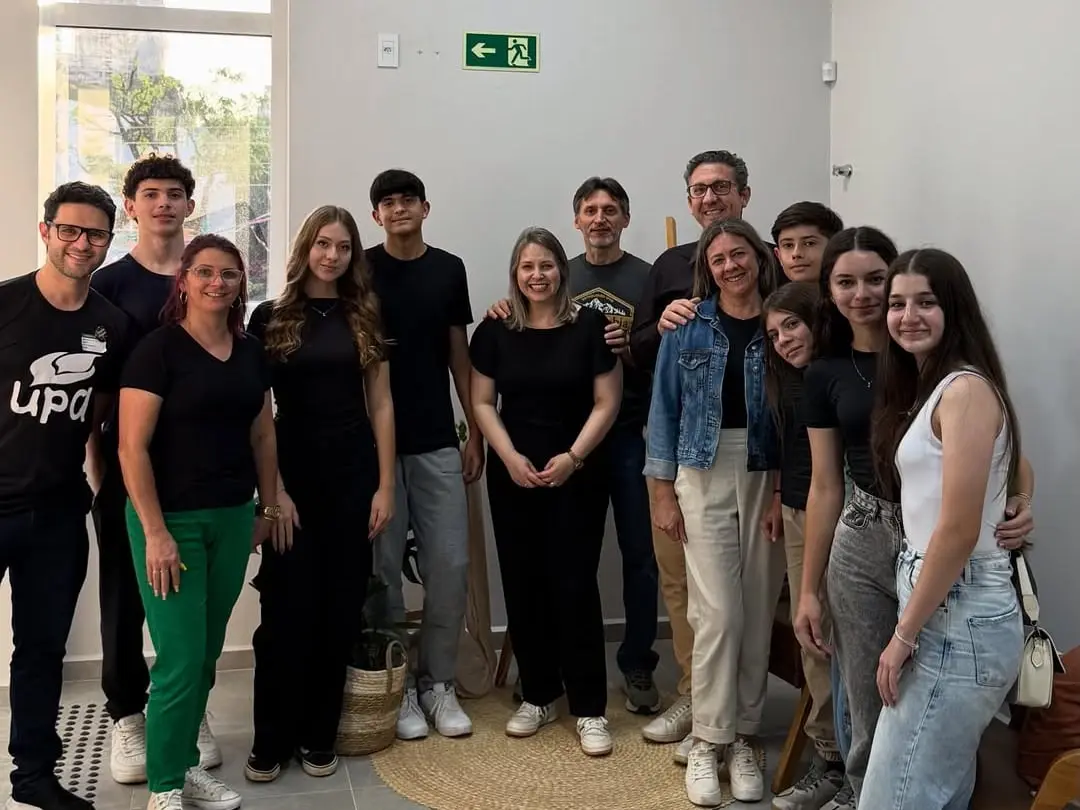 Adolescentes da UPA e líderes juntos numa sala da igreja, um deles com a camiseta da UPA